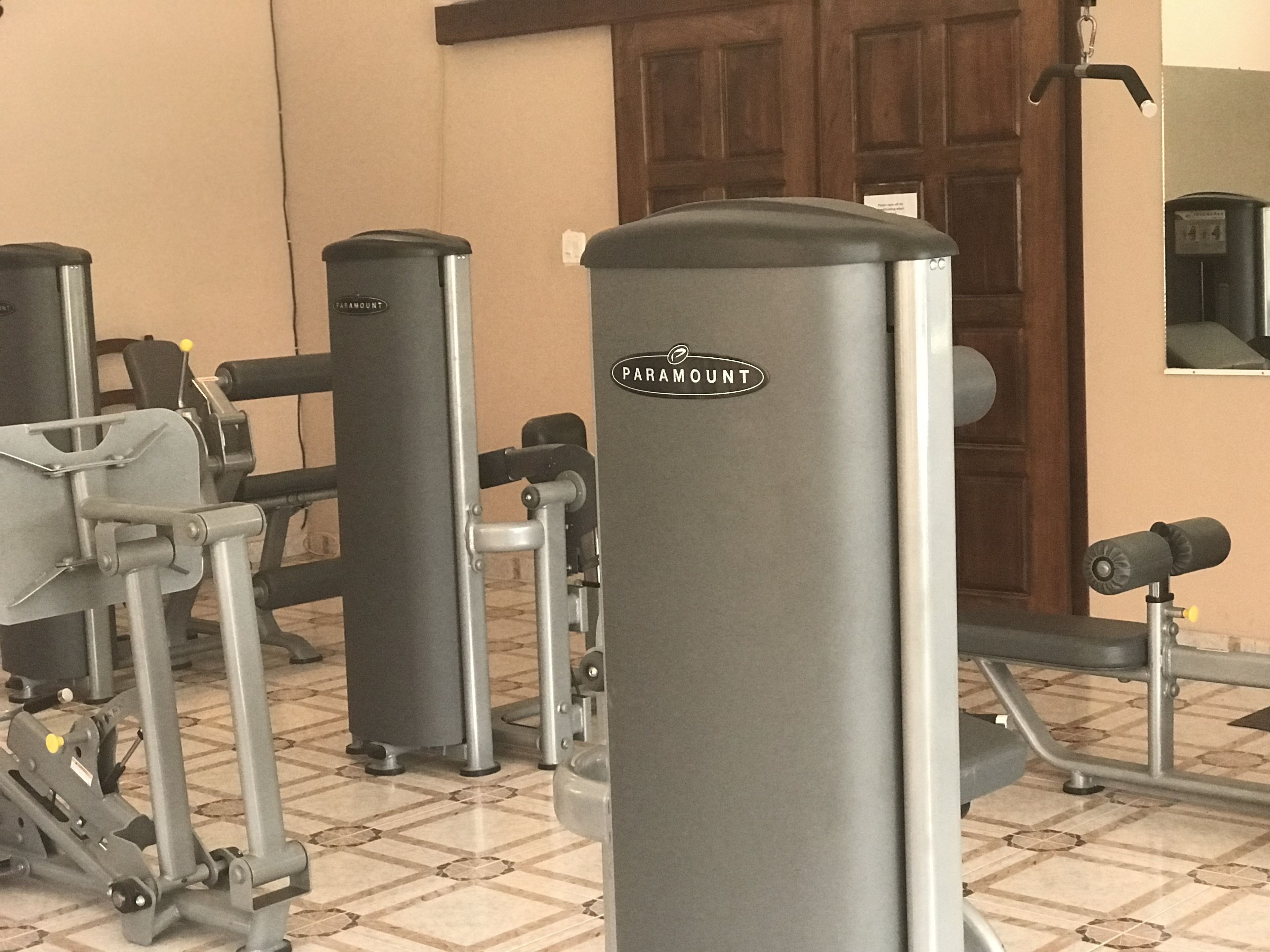 A gym with various exercise equipment, including a chest press machine and a pull-up bar.