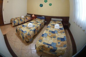 A hotel room with three single beds, each with a floral-patterned bedspread and a white towel on the bed. - Vale do Sonho Hotel & Eventos (Guararema)