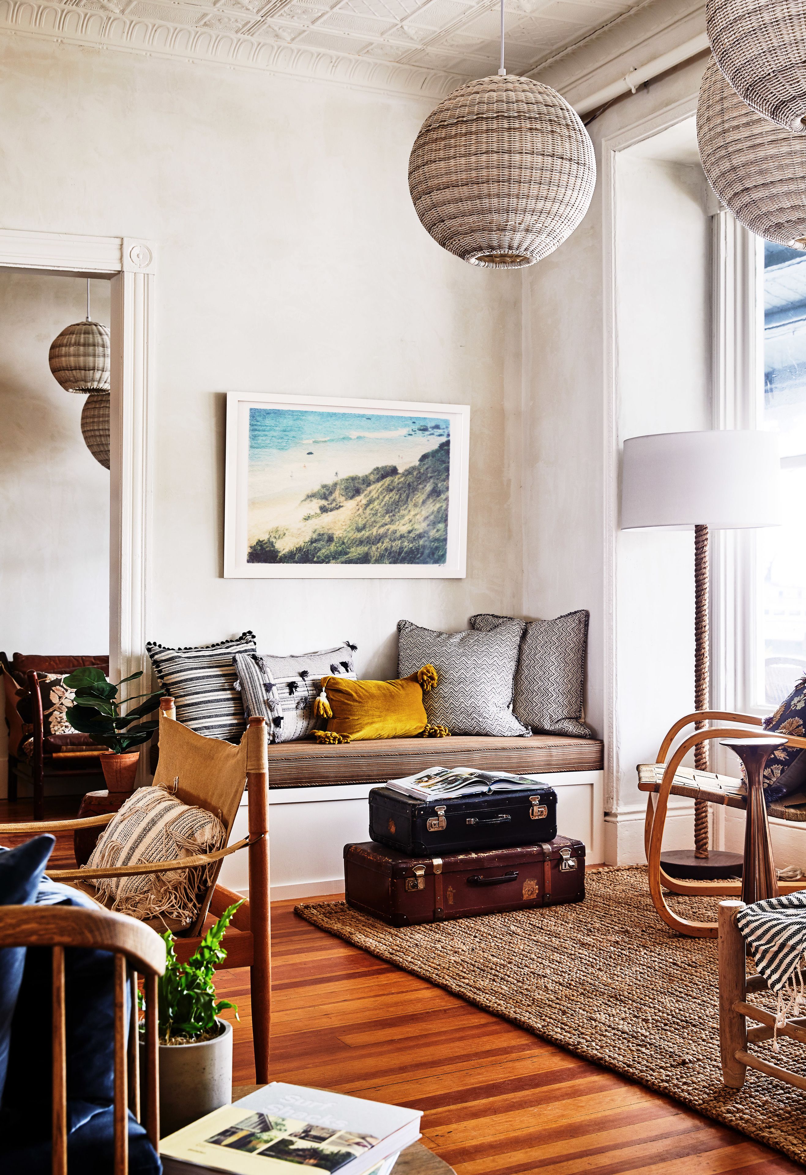 A cozy living room with a wooden bench, a rug, and a suitcase.