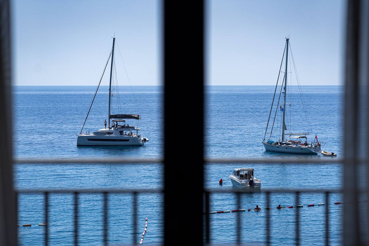 Un port de plaisance avec deux voiliers et un petit bateau à moteur.