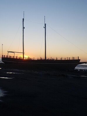 Un grand navire a accosté à un quai au coucher du soleil.