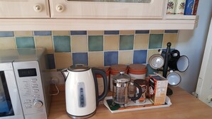A kitchen with a microwave, coffee maker, and various containers on the counter. - Lingdale 4 Bedroom House & Trundlebed Option (Saltburn-by-the-Sea)