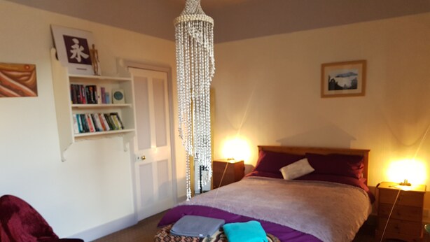 A bedroom with a bed, bedside lamps, a bookshelf, and a decorative chandelier. - Lingdale 4 Bedroom House & Trundlebed Option (Saltburn-by-the-Sea)