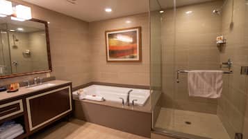 A modern bathroom with a glass-enclosed shower, a large bathtub, and a vanity with a mirror.