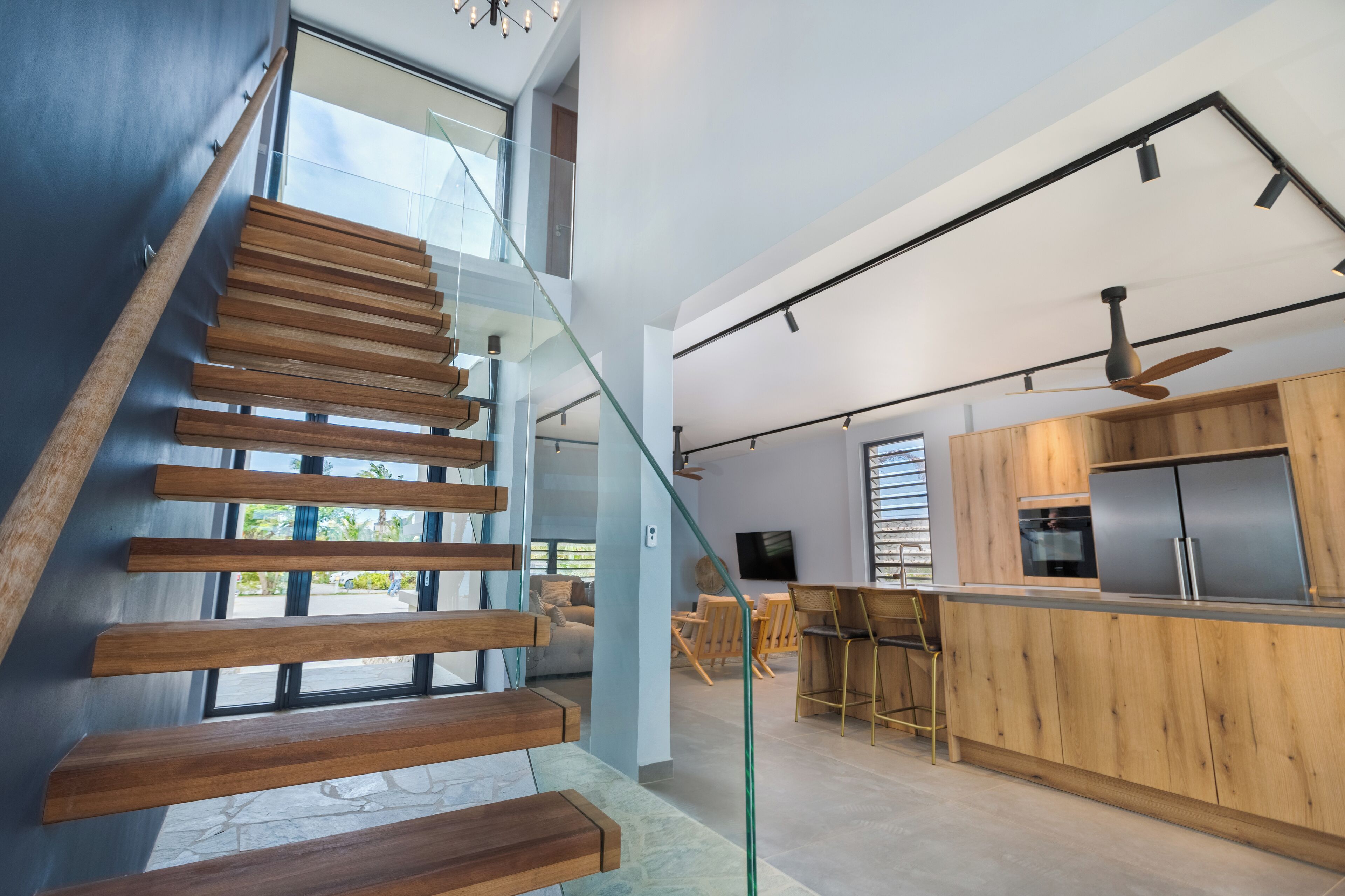 A modern kitchen with wooden cabinetry, a built-in oven, and a bar area.