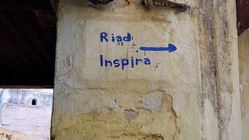 A wall with a blue arrow pointing right and the words "Riad Inspira" written on it.
