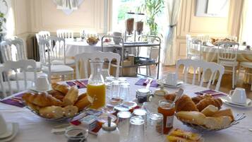 A breakfast buffet with croissants, pastries, and juice.