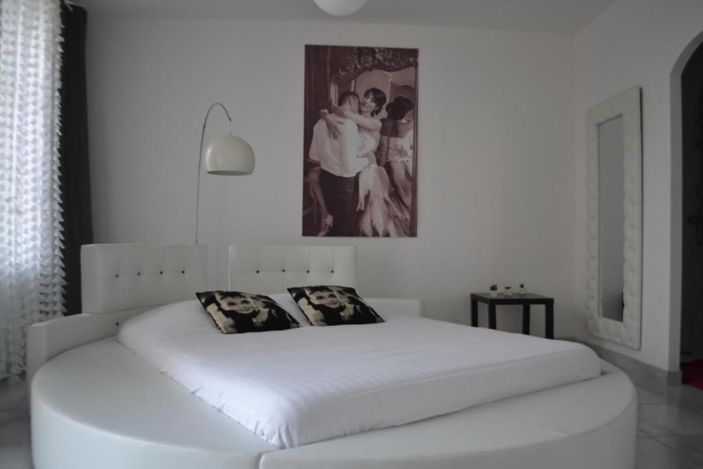 Un dormitorio moderno con cama redonda, lámpara de pared e imagen enmarcada.