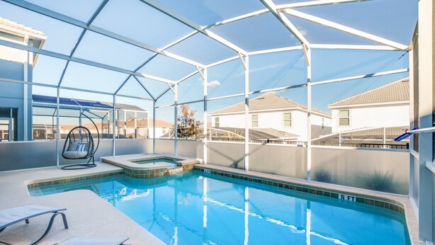 En pool på taget med glasfacade, et boblebad og en liggestol.
