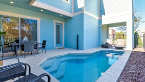 Ett modernt hus med en swimmingpool, utemöbler och en uteplats.