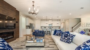 A modern living room with a large flat-screen TV, a sofa set, and a coffee table. - Solara Resort 9031 D (Kissimmee)