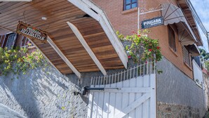 Un edificio con techo de madera y fachada de ladrillo. Se observa un letrero que dice 