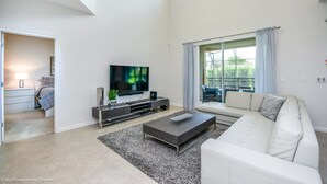 A modern living room with a flat-screen TV, a white sofa, and a coffee table. - Solterra 5196 (Davenport)