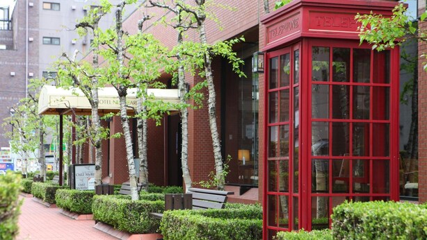 A red telephone booth and a hotel sign with a green awning. - Hotel New Carina (Morioka)