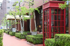 A red telephone booth and a hotel sign with a green awning. - Hotel New Carina (Morioka)