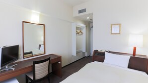 A hotel room with a bed, a desk with a chair, a TV, a bedside table with a lamp, and a wardrobe. - Hotel New Carina (Morioka)