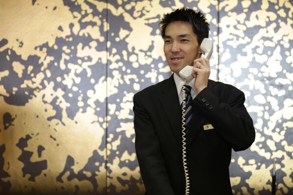 A man in a suit holding a telephone.