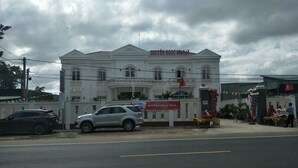A hotel with a white facade and a red roof, featuring a signboard with the hotel's name. - Hotel Nguyen Ngoc (Cu Jut)