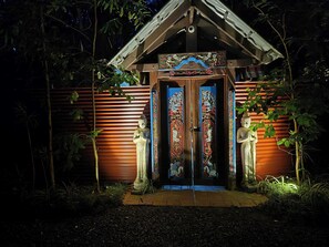 A temple entrance with two statues, a wooden structure, and a sign indicating private property.