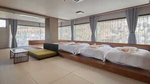 A modern hotel room with a large bed, a small table, and a bench. - Mission Hills Hotel (Minano)