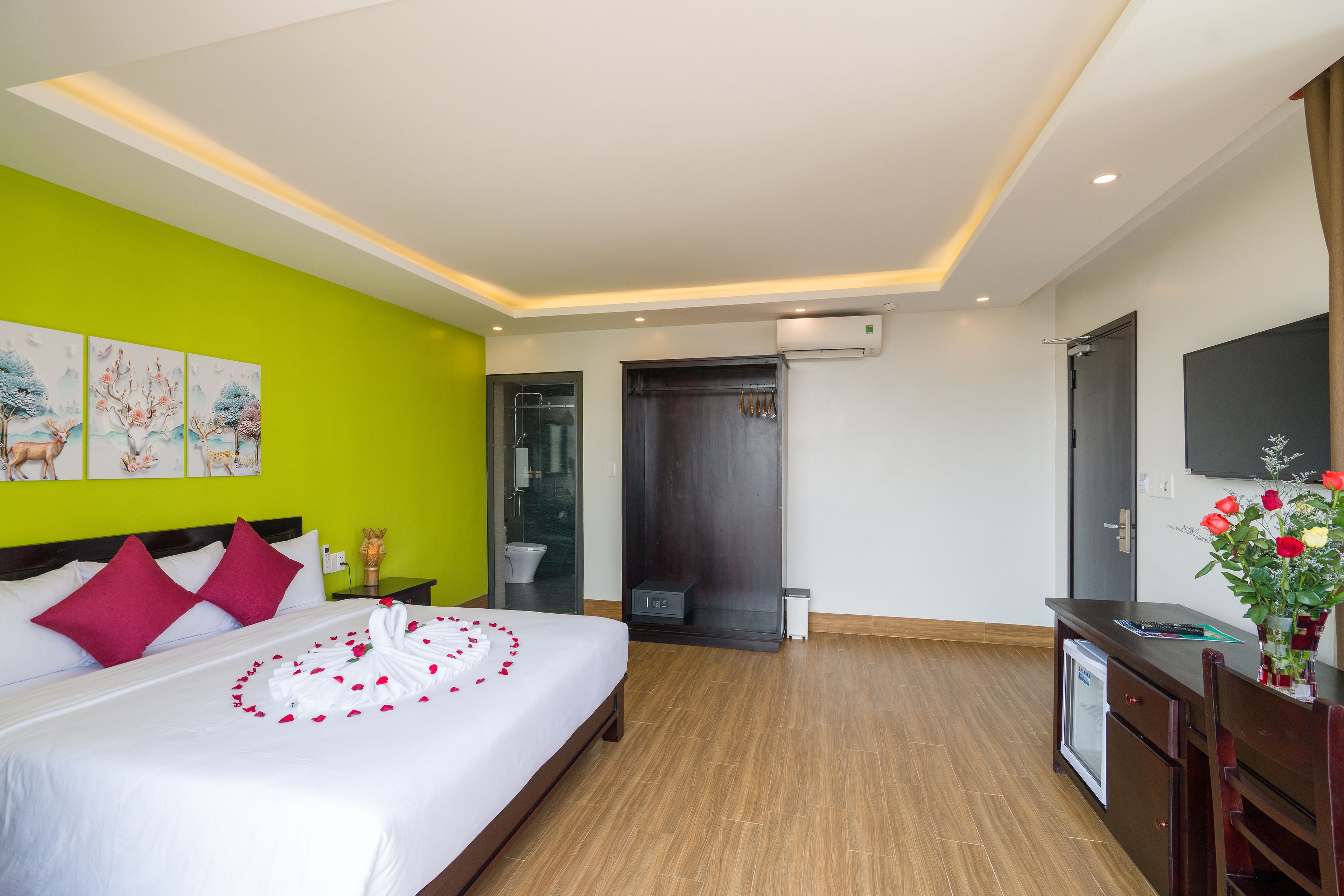 Una habitación de hotel con cama, escritorio, televisión y zona de ducha.