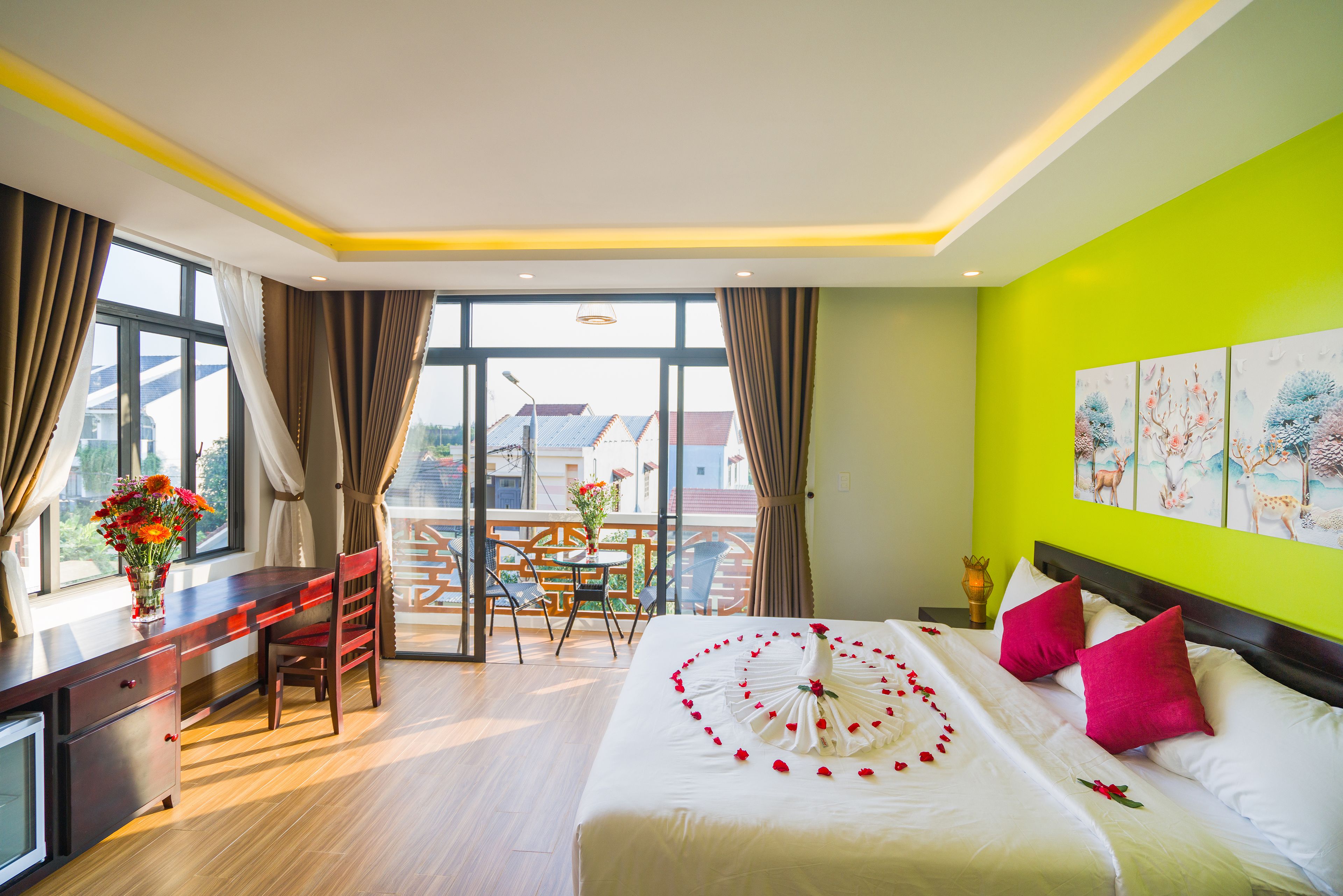 A hotel room with a bed, a desk, and a balcony.