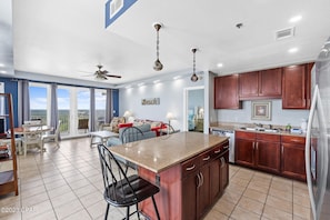 A spacious kitchen with a large island, wooden cabinets, and a view to the outside. - 1538 Large 3 Bedrooms, 3 Bathrooms, Bunkroom Nook, 10 guests (Panama City Beach)
