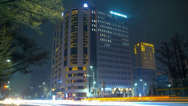 A multi-story hotel with illuminated signage, a prominent entrance, and a modern architectural design. - UB Grand Hotel (Ulaanbaatar)