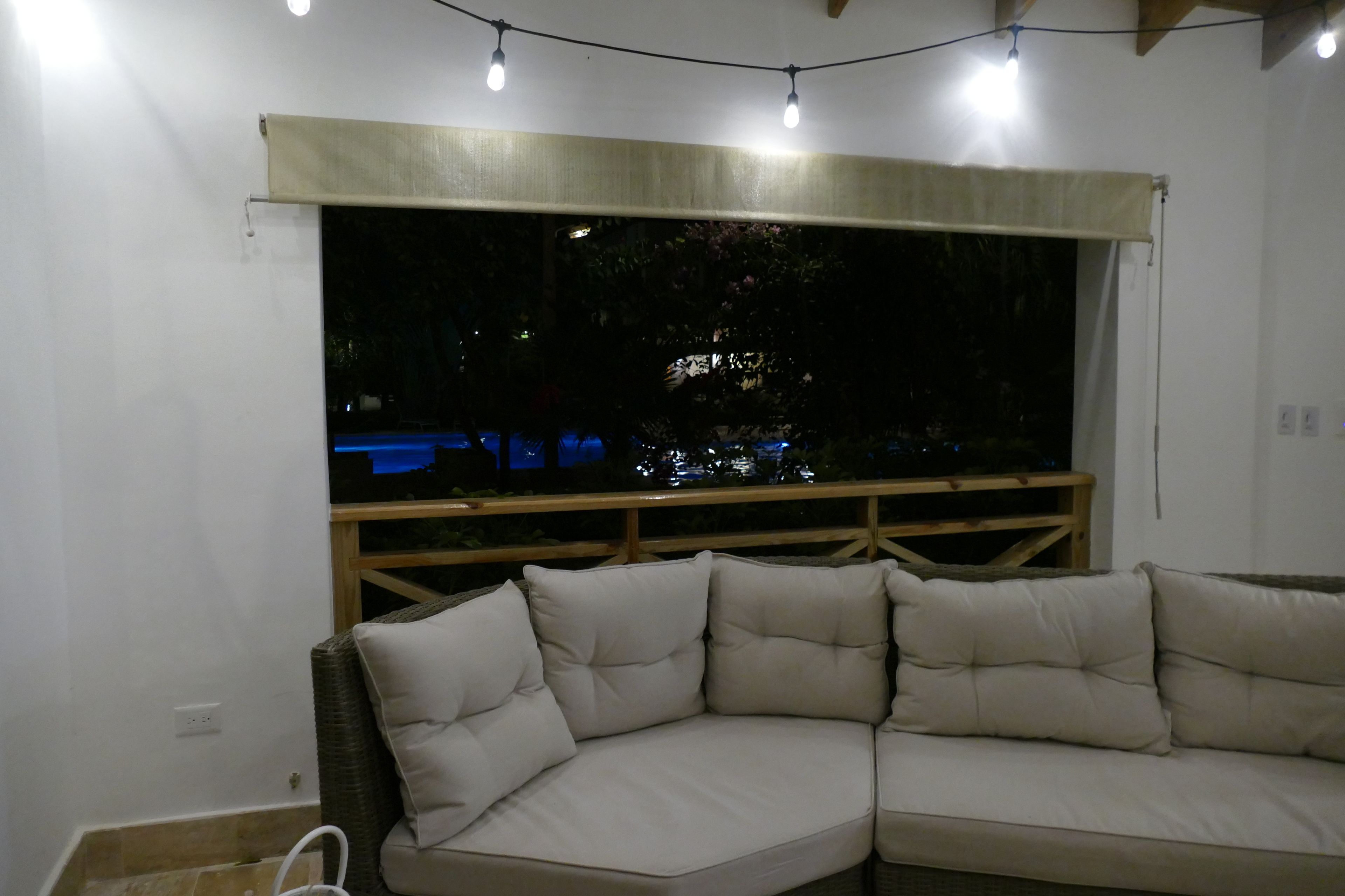 A corner sofa with a view of a balcony and a railing.