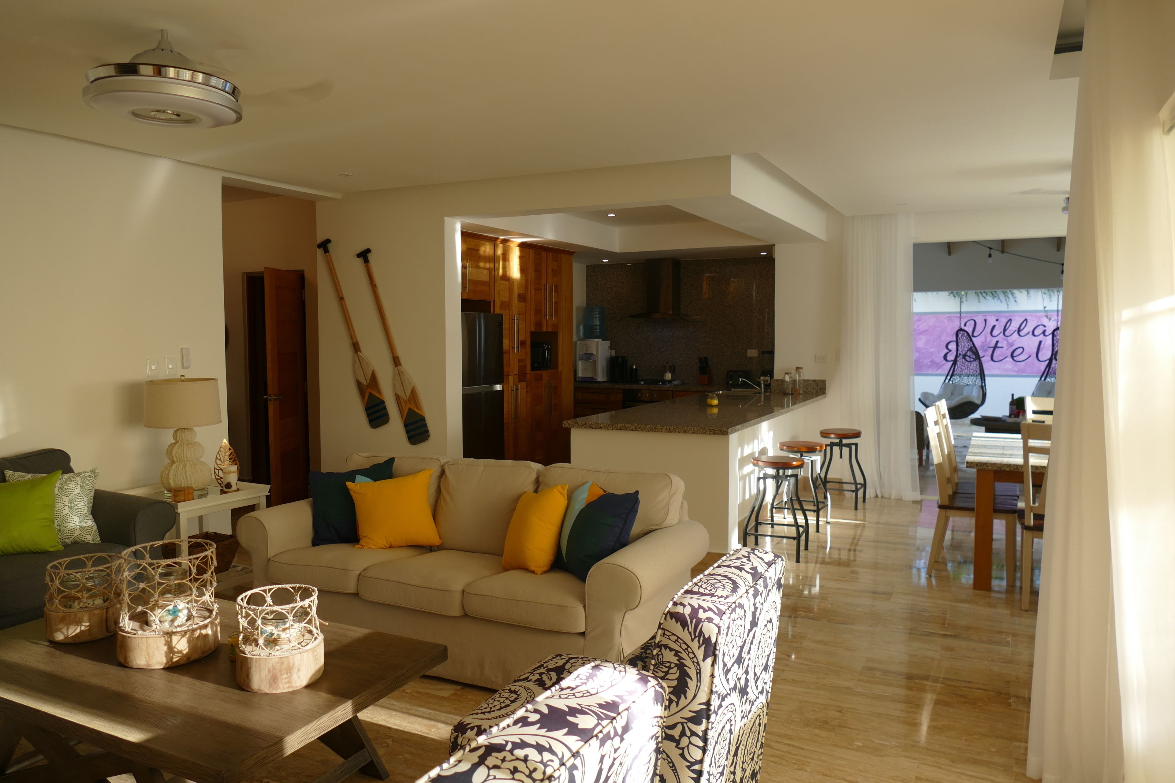 A spacious living room with a sofa, coffee table, and a dining area with chairs and a table.