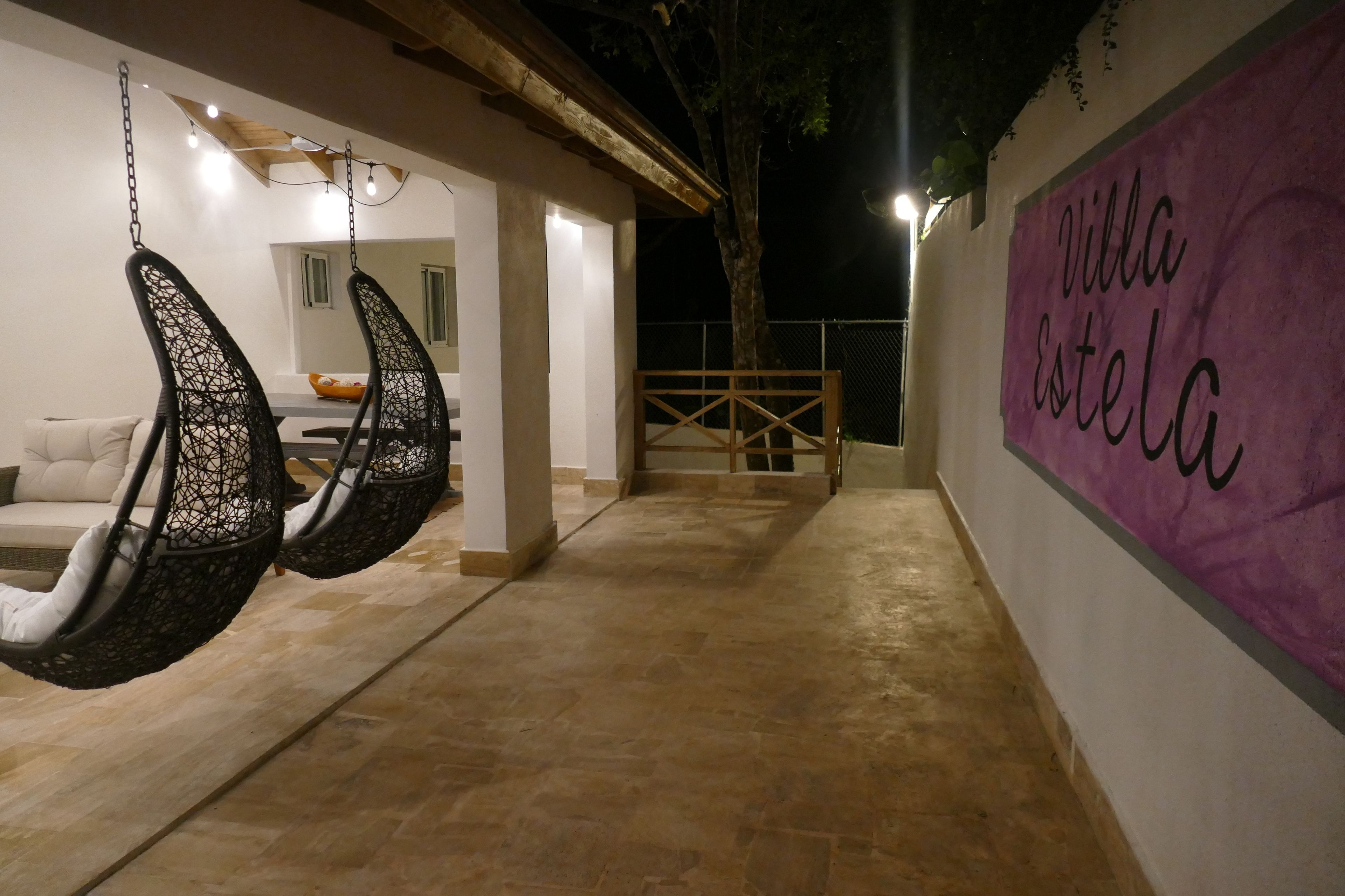 A hallway with hanging chairs and a sign reading "Villa Estela".