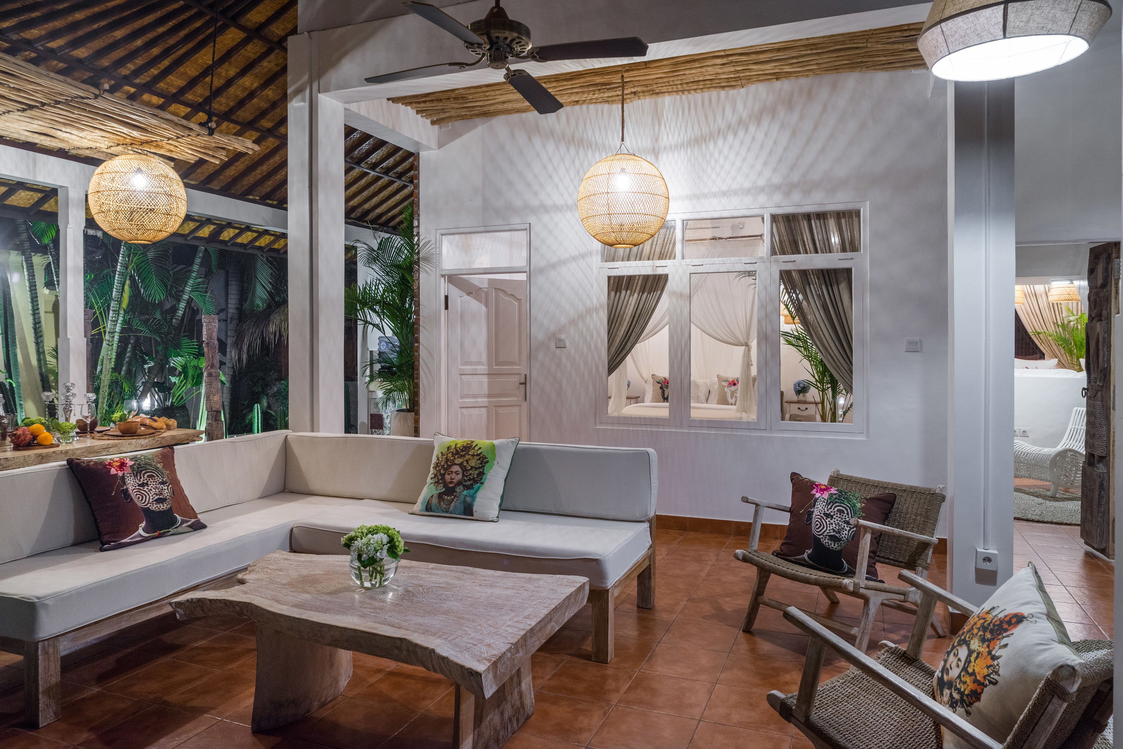 A spacious living area with a sofa, chairs, a coffee table, and a ceiling fan.