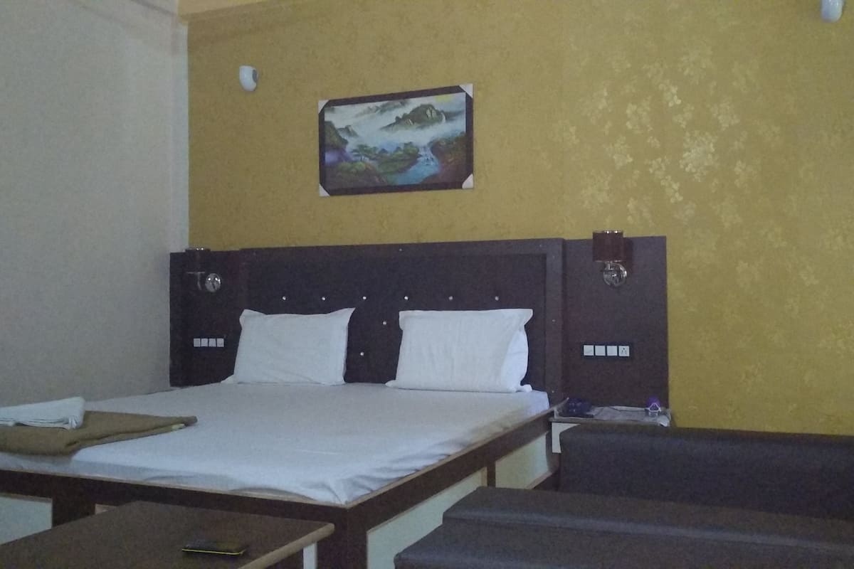 A hotel room with a bed, a desk, and a chair.