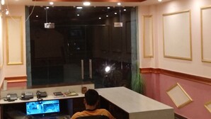 Una habitación con un escritorio, una computadora y un televisor mostrando imágenes de seguridad.