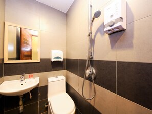 Un bany amb un lavabo, vàter i dutxa.