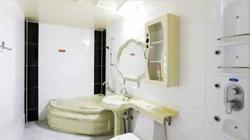 A bathroom with a bathtub, a sink, a mirror, and a shower enclosure.