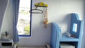 A small room with a bed, a desk, a window, and a blue storage unit. - Haisu Homestay (Hengchun)