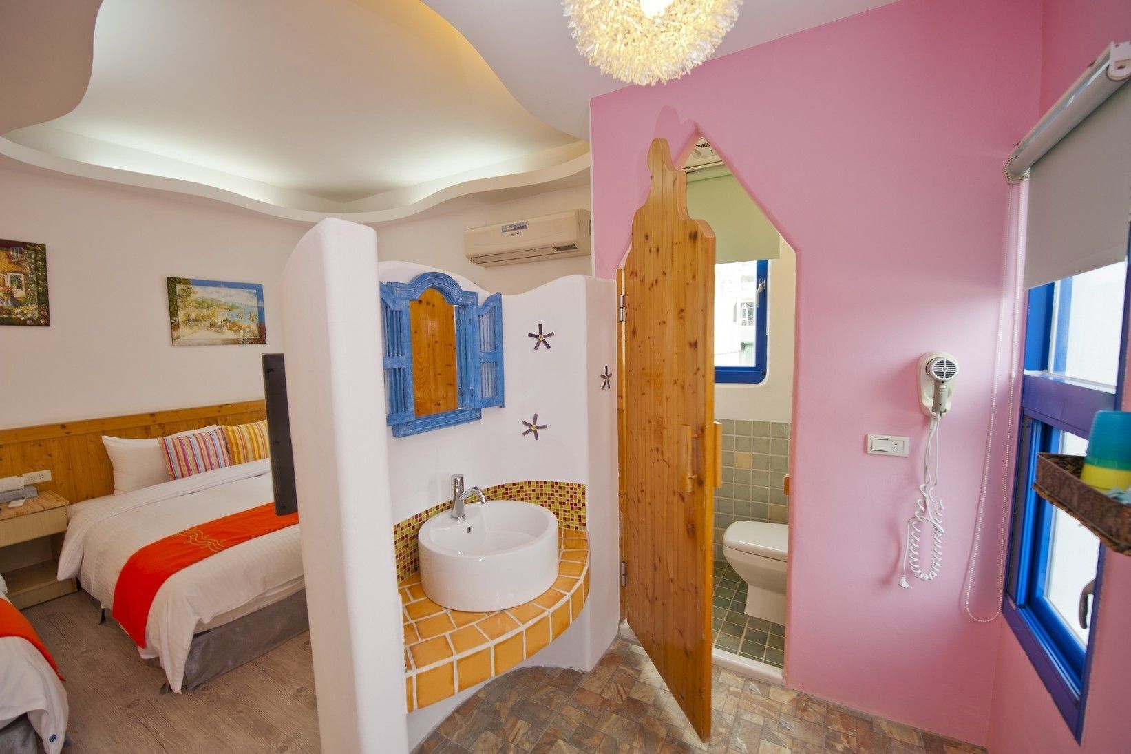 Un dormitorio con cama, mesita de noche, espejo y ventana.