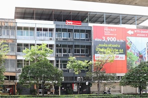 A building with multiple floors, featuring a sign for "OYO Oliver's Hostel" and a large advertisement for "The Privacy SIOI Sukhumvit 101". - OYO 823 Oliver’s Hostel (Bangkok)