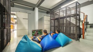 Een modern interieur met een zithoek, blauwe kussens, een trap en een metalen scheiding.