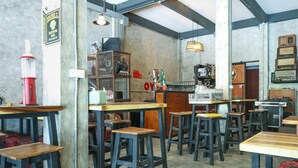 Een bar met houten krukken, oude radio's en een Shell benzinestation.
