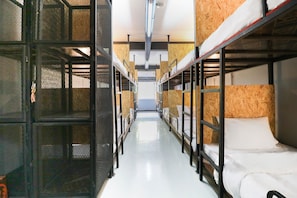 A corridor with bunk beds, metal mesh partitions, and a white floor. - OYO 823 Oliver’s Hostel (Bangkok)