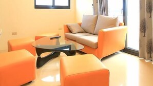 A modern living room with a sofa, ottoman, and coffee table. - Amethyst Bay (Magong)