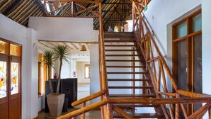 Un escalier en bois avec une rampe métallique menant à un deuxième étage.