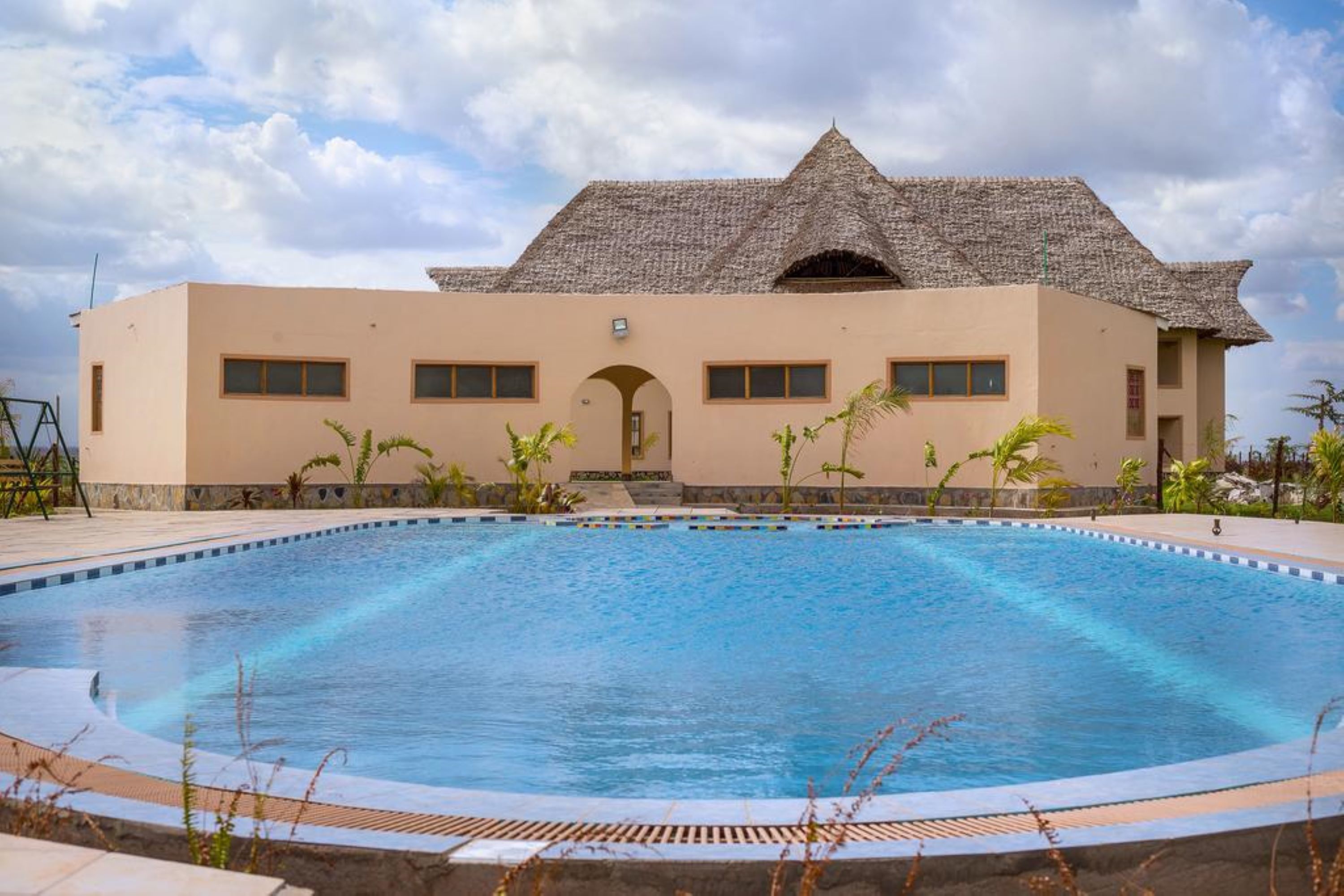 Una piscina con un edificio al fondo.