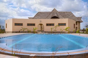 Una piscina con un edificio al fondo.