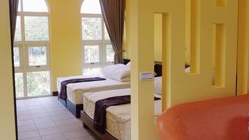 A hotel room with two beds, a large window, and a door leading to another room.