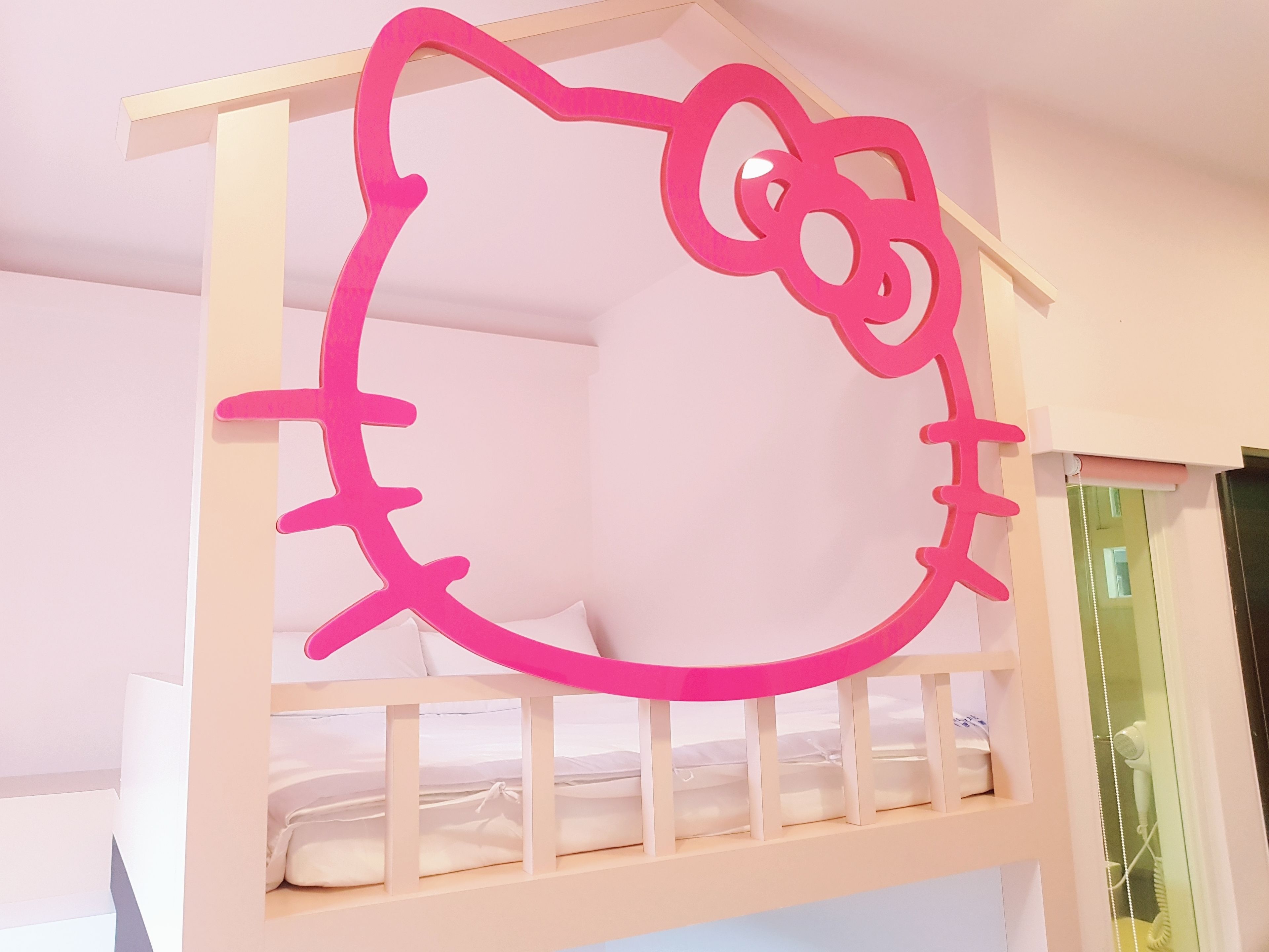 A bunk bed with a Hello Kitty design on the headboard.