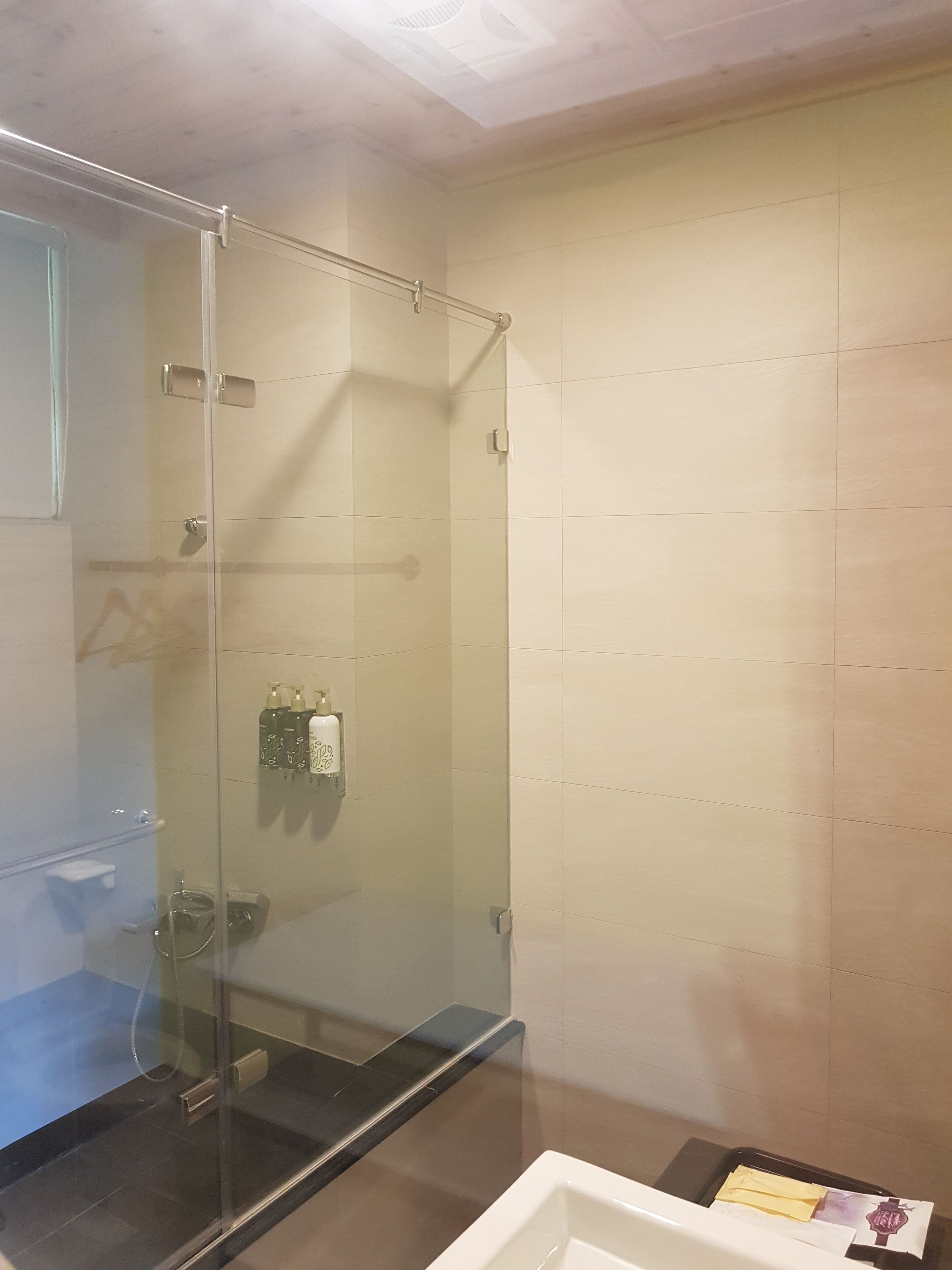 Un baño moderno con cabina de ducha de vidrio, inodoro y lavamanos.