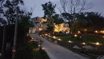 Un edificio de dos plantas con un camino de piedra que lleva a la entrada.